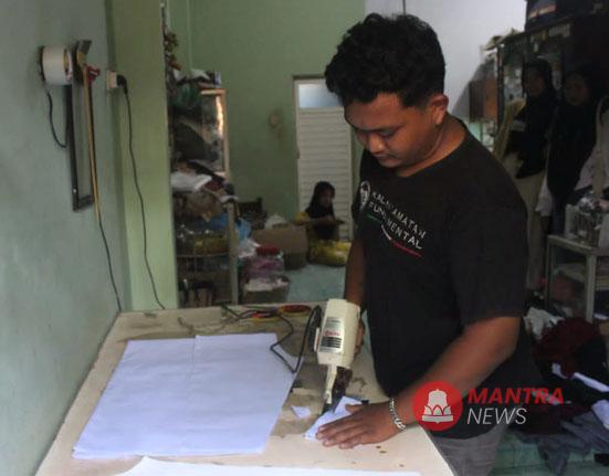 Salah satu karyawan sedang memotong pola kain