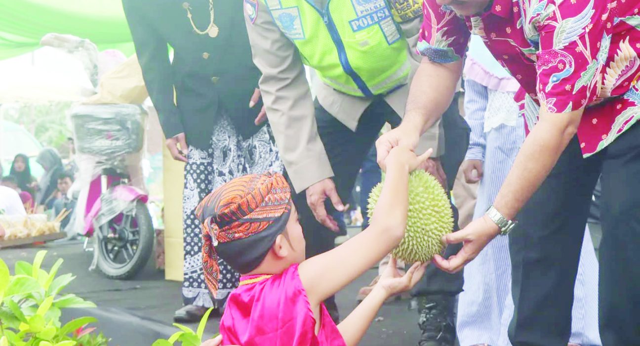Bupati Semarang Ngesti Nugraha sedang memberikan durian dalam kegiatan merti dusun di Dusun Gintungan, Desa Gogik, Kecamatan Ungaran Barat, Kabupaten Semarang, Minggu, 29 Desember 2024.