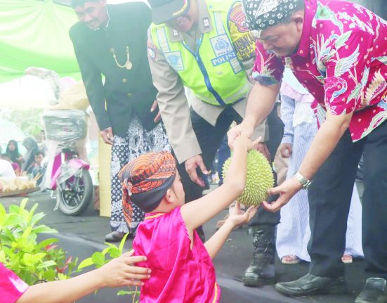 Bupati Semarang Ngesti Nugraha sedang memberikan durian dalam kegiatan merti dusun di Dusun Gintungan, Desa Gogik, Kecamatan Ungaran Barat, Kabupaten Semarang, Minggu, 29 Desember 2024.