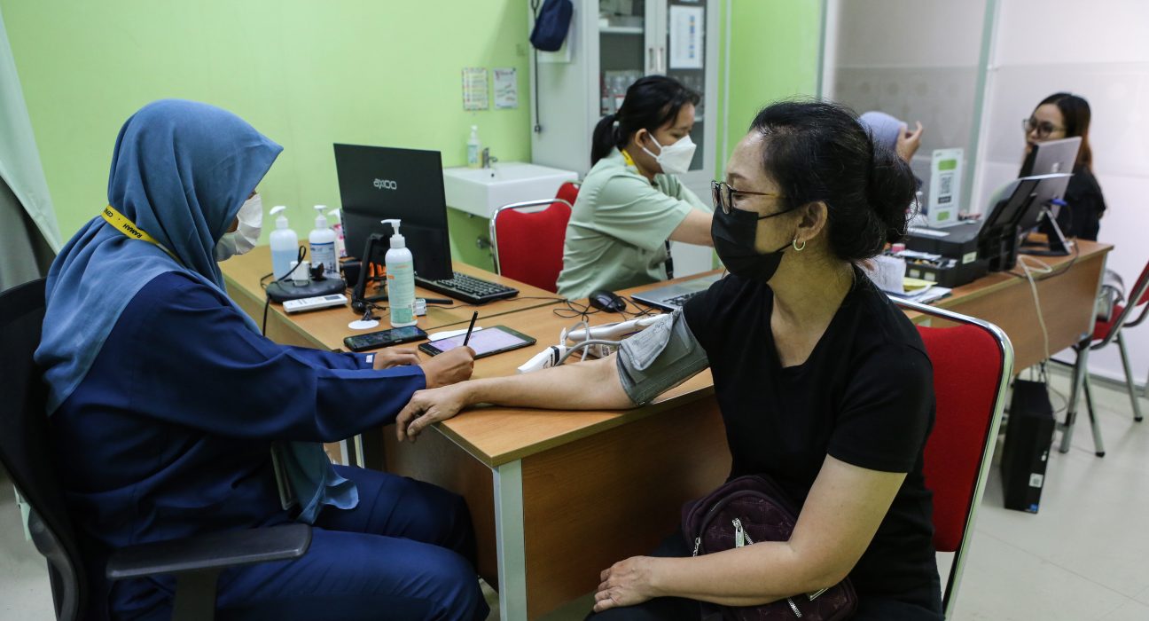 Seorang petugas kesehatan sedang memeriksa pasien. Seluruh masyarakat Indonesia berhak merasakan prograam UHC yang didanai APBD.