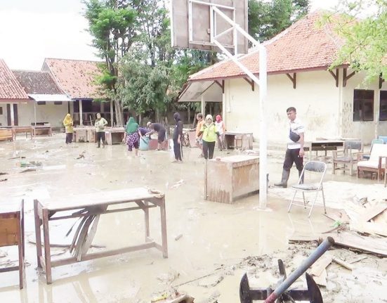 Para relawan dan guru SMP Negeri 2 Patebon, Kabupaten Kendal sedang bersih-bersih meja dan kursi pasca-banjir, beberapa waktu lalu
