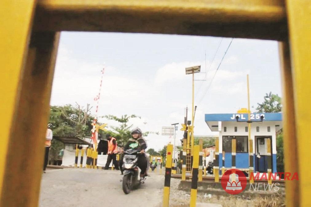 Petugas berjaga mengatur lalu lintas sementara pengendara melintasi jalur perlintasan langsung di Desa Ketanon, Tulungagung, Minggu (16/2). (ant | Mantranews.id)