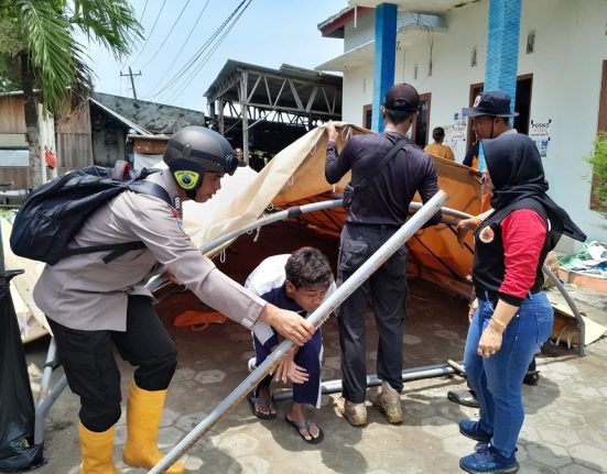Petugas gabungan sedang membongkar tenda dapur umum milik Dinsos P2PA Kabupaten Demak, Kamis , 13 Februari 2025. Di mana dapur itu sebelumnya digunakan untuk melayani kebutuhan logistik warga terdampak banjir. (M. Burhanuddin A. | Mantranews.id)