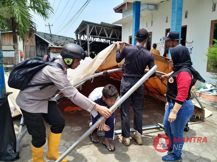 Petugas gabungan sedang membongkar tenda dapur umum milik Dinsos P2PA Kabupaten Demak, Kamis , 13 Februari 2025. Di mana dapur itu sebelumnya digunakan untuk melayani kebutuhan logistik warga terdampak banjir. (M. Burhanuddin A. | Mantranews.id)