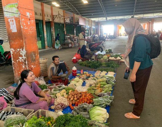 Pedagang sayur di Pasar Bintoro, Demak sedang menunggui lapaknya, Selasa (25/2). (M. Burhanuddin A. | Mantranews.id)