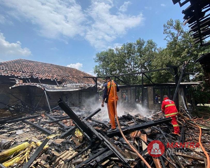 Petugas Damkar melakukan pendinginan rumah warga yang terbakar di Desa Tlogorejo, Kecamatan Karangawen, Kabupaten Demak, Senin (3/3). (M. Burhanuddin | Mantranews.id)