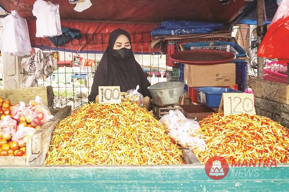 Seorang pedagang sedang menimbang cabai pesanan pembelinya. (Anta | Mantranews.id)
