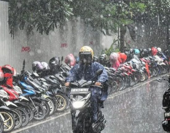 Seorang pengendara motor menerobos guyuran hujan dengan intensitas lebat. (Anta | Mantranews.id)