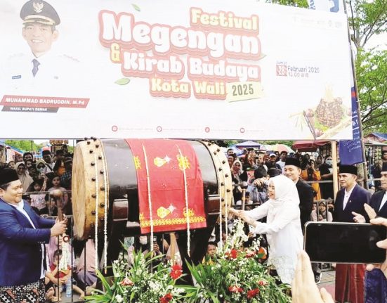 Bupati Demak Eisti’anah memukul bedug sebagai tanda dibukanya Festival Megengan, Jumat (28/2). (M. Burhanuddin A. | Mantranews.id)