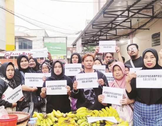 Sejumlah pedagang pasar pagi di kawasan Pasar Raya 1 Salatiga membentangkan poster sebagai wujud penolakan relokasi pedagang, belum lama ini. (Angga Rosa | Mantranews.id)