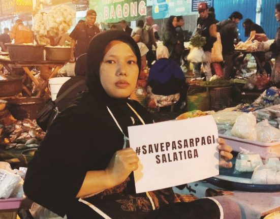 Seorang pedagang pasar pagi Kota Salatiga menunjukkan poster bentuk penolakan relokasi pasar, beberapa waktu lalu. (Angga Rosa | Mantranews.id)