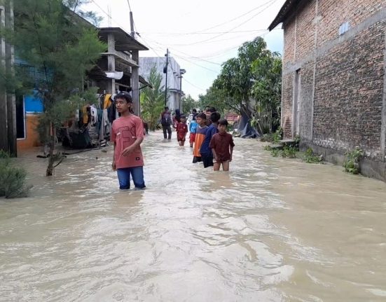 Sejumlah anak-anak bermain air di lingkungan rumahnya yang sedang digenangi banjir. (M. Burhan A | Mantranews.id)