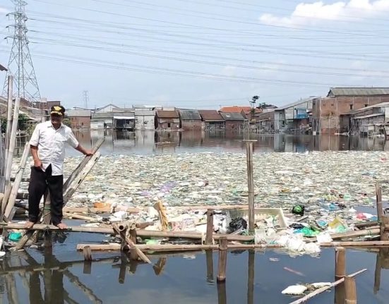 Seorang warga sedang menengok bekas tambak ikan yang menjelma jadi pulau sampah di Kampung Tambakrejo, Kelurahan Tanjung Emas, Kecamatan Semarang Utara, Kota Semarang. (Lingkar Media Group Network)