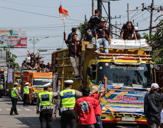 Sejumlah polisi lalu lintas mengarahkan sopir truk yang melakukan aksi solidaritas menolak aturan Over Dimension Over Load (ODOL) di Jalur Pantura Siliwangi Ruas Semarang-Kendal, Semarang, Jawa Tengah, Senin (23/6/2025). (Lingkar Media Group Network)