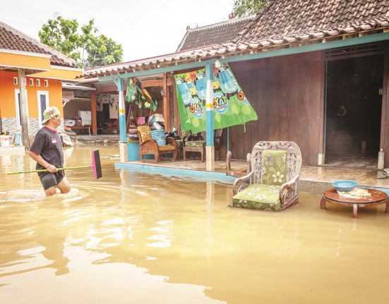 Warga membersihkan rumahnya yang tergenang banjir di Desa Tanggirejo, Tegowanu, Grobogan, Jawa Tengah, Kamis (19/6/2025). (Lingkar Media Group Network)