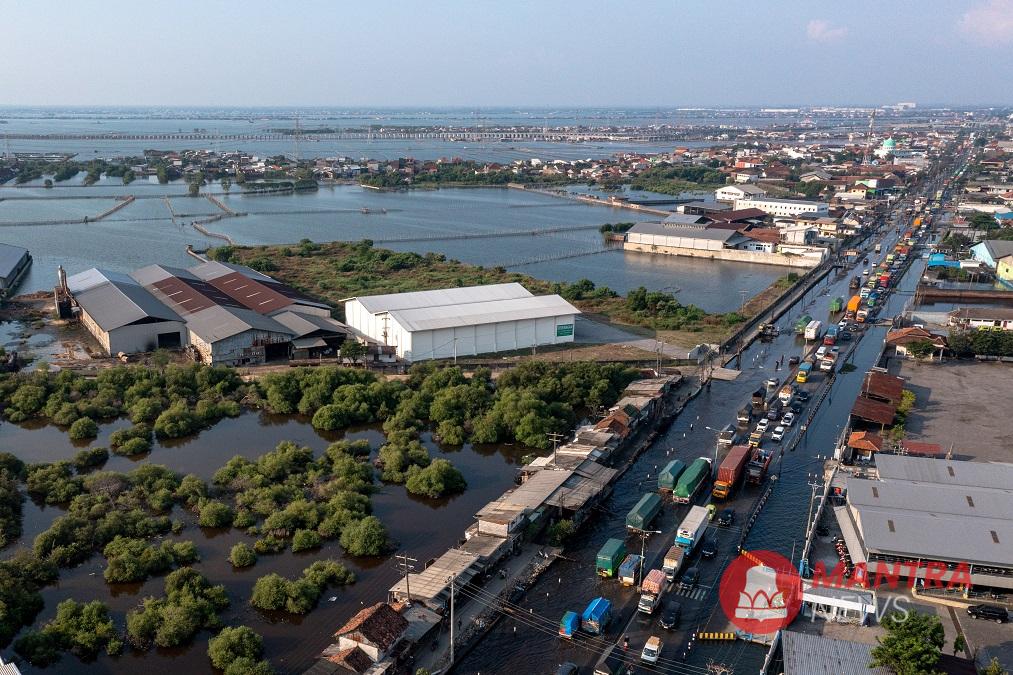 Kendaraan bermotor melaju perlahan menembus jalan raya pantura Demak KM Surabaya-Semarang di Kecamatan Sayung, Kabupaten Demak, Jawa Tengah yang terendam rob. (Lingkar Media Group Network)
